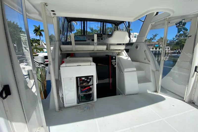 Slide: The Image of 2003 Carver 356 Motor Yacht interior with helm, seating, and storage, docked in sunny marina. - 14