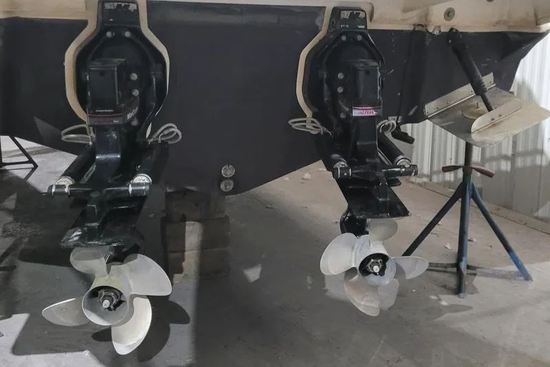 Slide: The Image of 2004 Searay 280 Sundancer boat propellers and outdrives in a storage facility. - 16