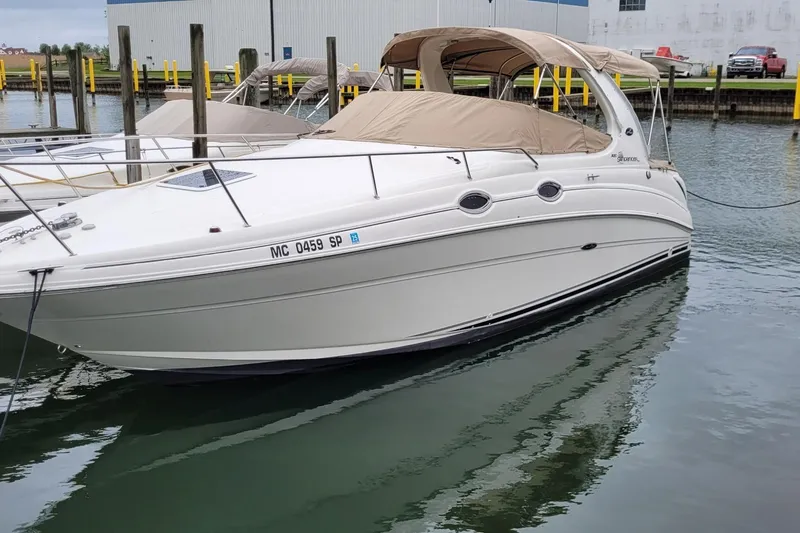 Slide: The Image of 2004 Searay 280 Sundancer boat docked in marina, featuring beige canopy. - 22