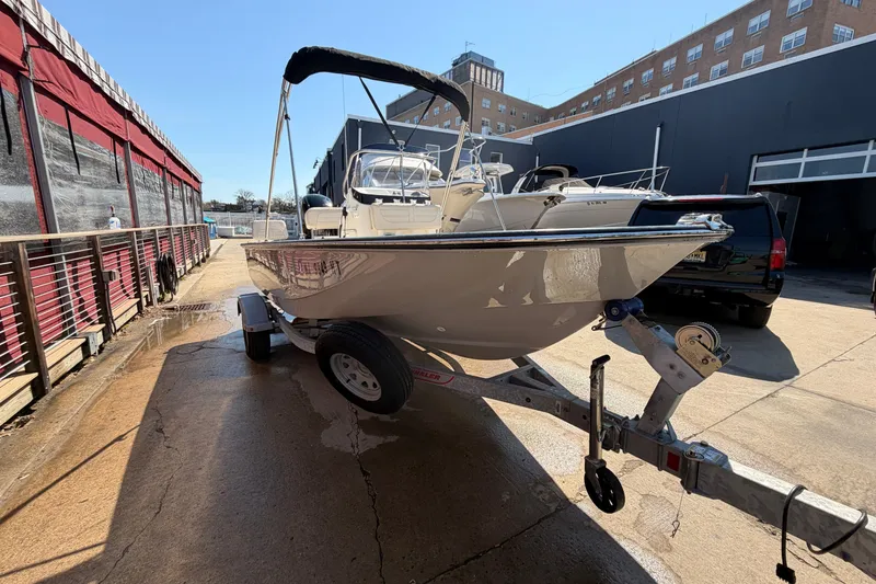 Slide: The Image of 2024 Boston Whaler 170 Montauk boat on trailer in urban setting. - 2