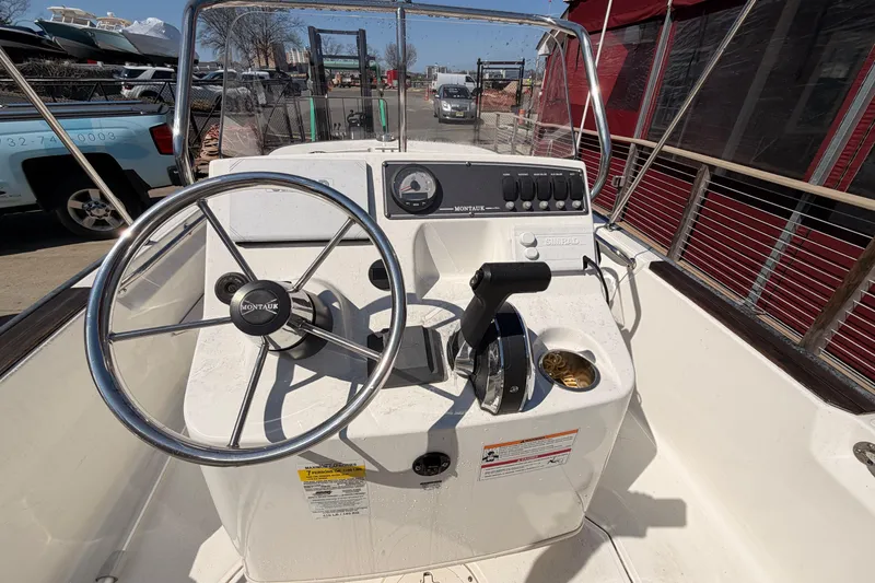 Slide: The Image of 2024 Boston Whaler 170 Montauk boat console with steering wheel and controls. - 7