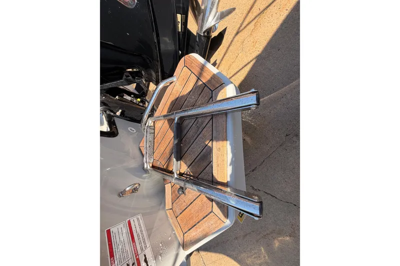 Slide: The Image of 2024 Boston Whaler 170 Montauk swim platform with ladder, featuring wood finish and metal rails. - 8