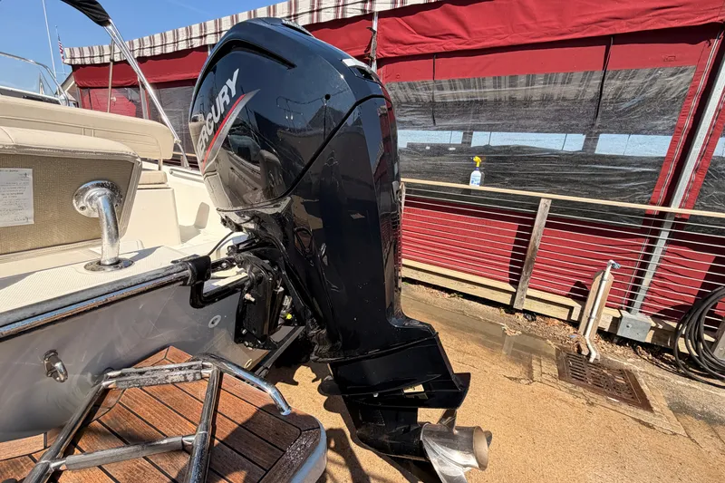 Slide: The Image of 2024 Boston Whaler 170 Montauk with Mercury outboard motor, docked near red awning. - 9