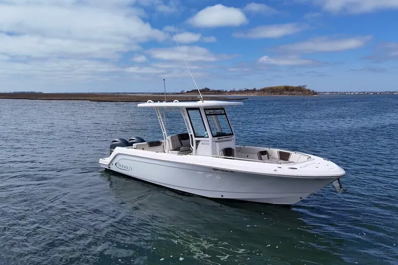 Slide: The Image of 2020 Robalo R272 Center Console boat on calm water under blue sky. - 12