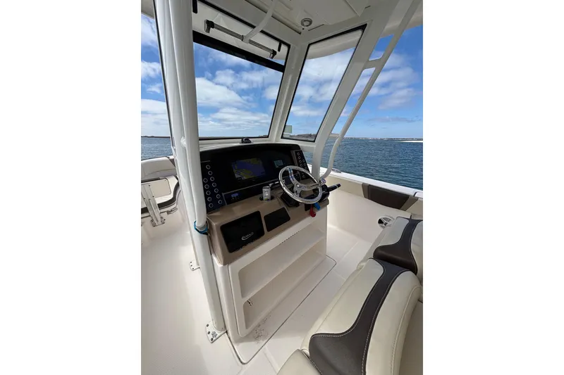 Slide: The Image of 2020 Robalo R272 Center Console boat interior with steering wheel and navigation system. - 18