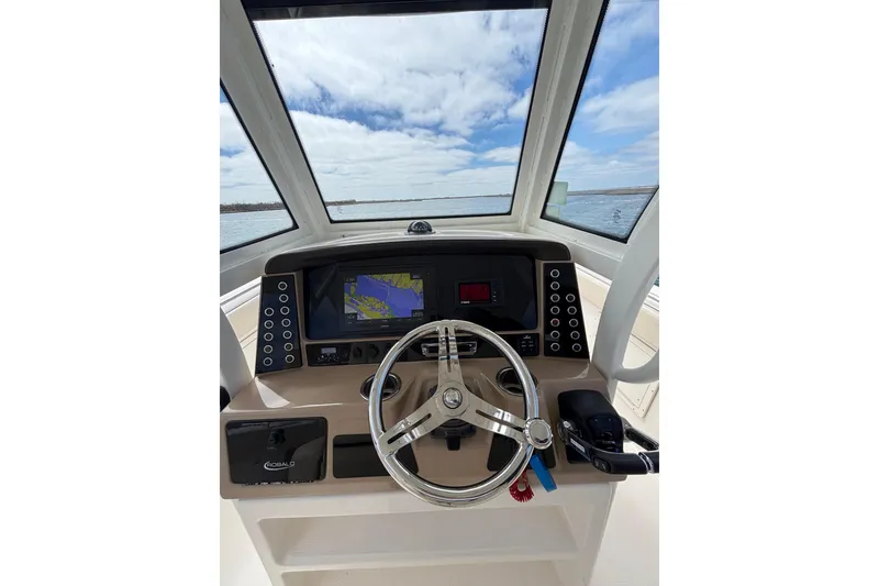 Slide: The Image of 2020 Robalo R272 Center Console helm with navigation display and steering wheel. - 19