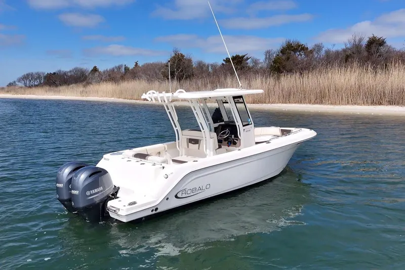 Slide: The Image of 2020 Robalo R272 Center Console boat with dual Yamaha engines on calm water. - 2
