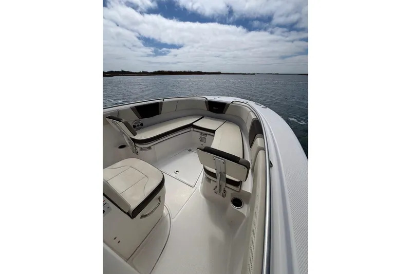 Slide: The Image of 2020 Robalo R272 Center Console boat interior with seating, on calm water under cloudy sky. - 20