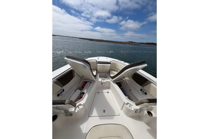 Slide: The Image of 2020 Robalo R272 Center Console boat with open storage compartments on calm water. - 22