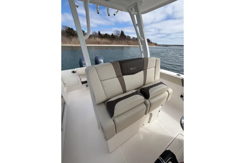 Slide: The Image of 2020 Robalo R272 Center Console boat interior with dual seats, on calm water. - 23