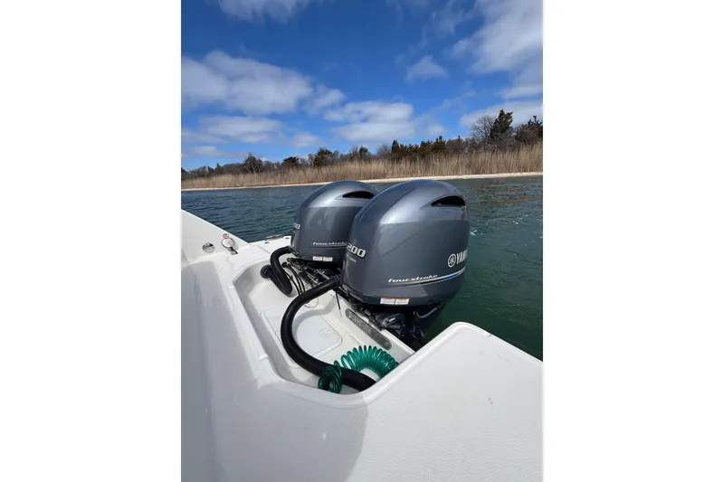 Slide: The Image of 2020 Robalo R272 Center Console with twin Yamaha outboard motors on a calm lake. - 33