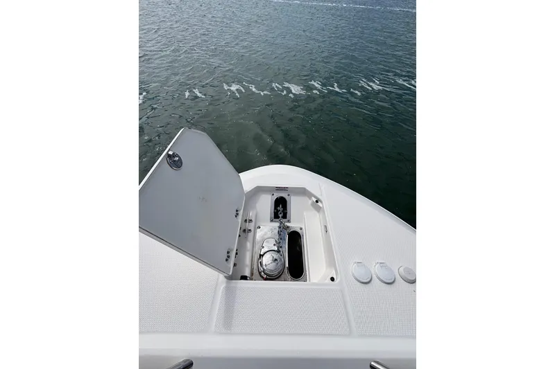 Slide: The Image of 2020 Robalo R272 Center Console boat anchor compartment open on calm water. - 38