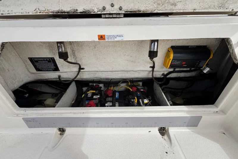 Slide: The Image of 2020 Robalo R272 Center Console battery compartment with wiring and charger. - 40