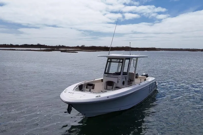 Slide: The Image of 2020 Robalo R272 Center Console boat on calm water under a cloudy sky. - 43