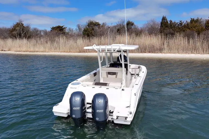Slide: The Image of 2020 Robalo R272 Center Console boat with dual engines on calm water. - 5