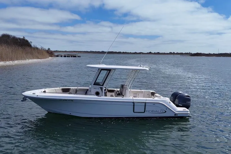 Slide: The Image of 2020 Robalo R272 Center Console boat on calm water under a cloudy sky. - 7