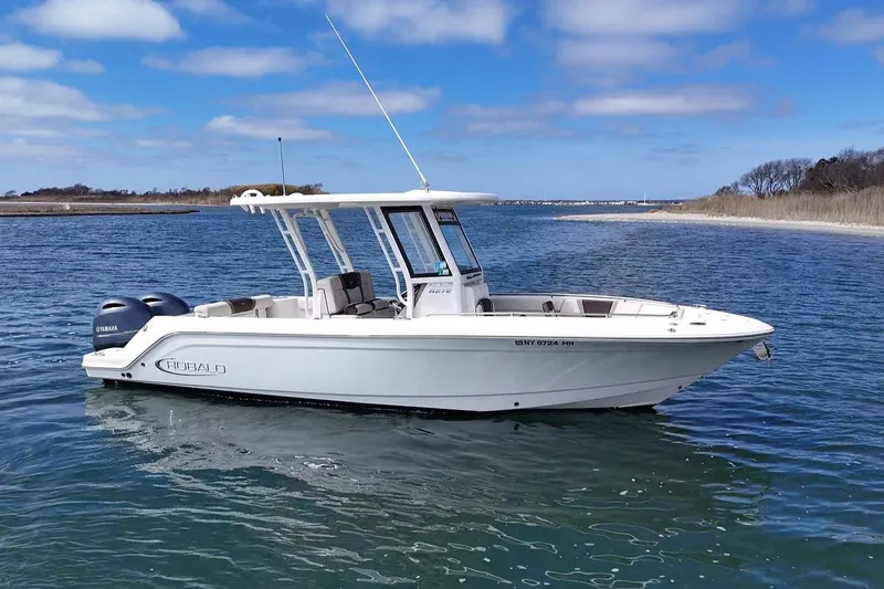 Slide: The Image of 2020 Robalo R272 Center Console boat on calm water under blue sky. - 8