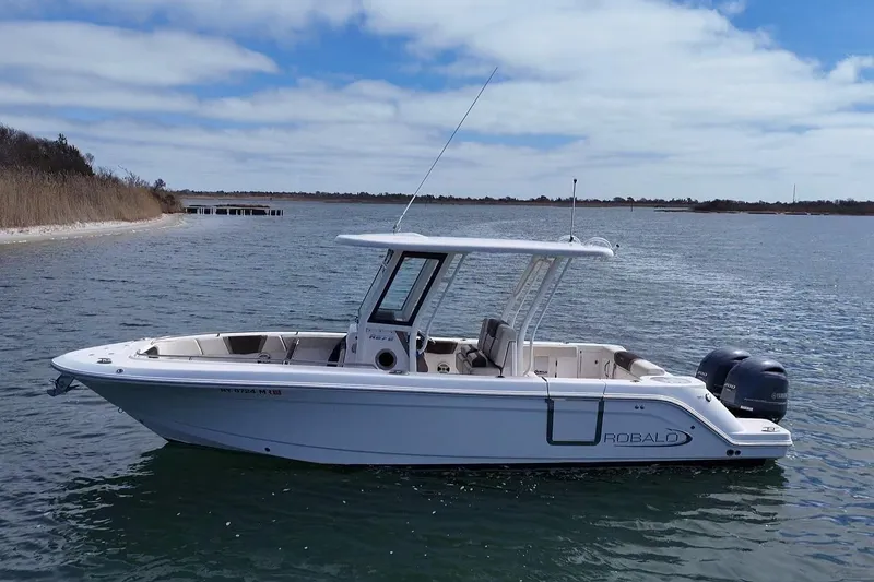 Slide: The Image of 2020 Robalo R272 Center Console boat on calm water under blue sky. - 9