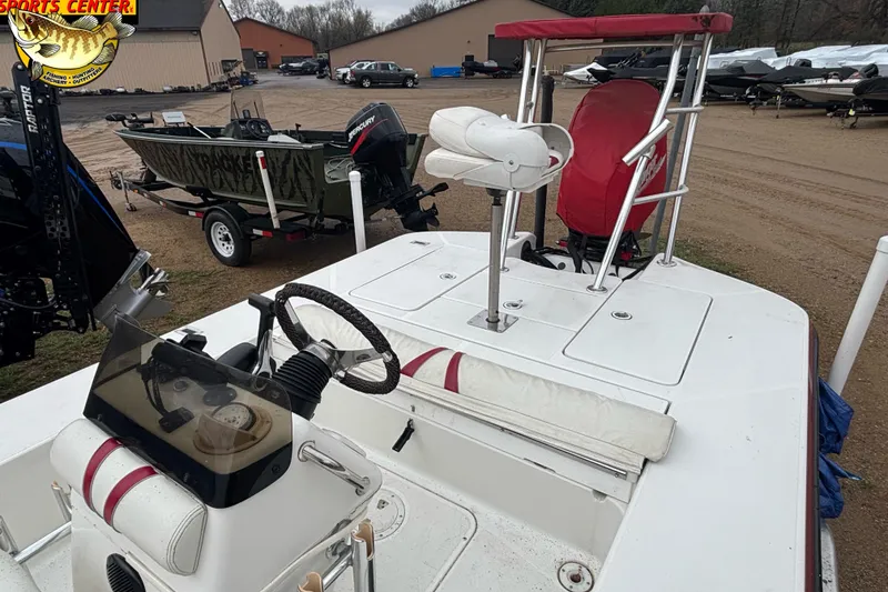 Slide: The Image of 2005 Ranger 223 Cayman boat with steering console and seating, parked outdoors. - 5