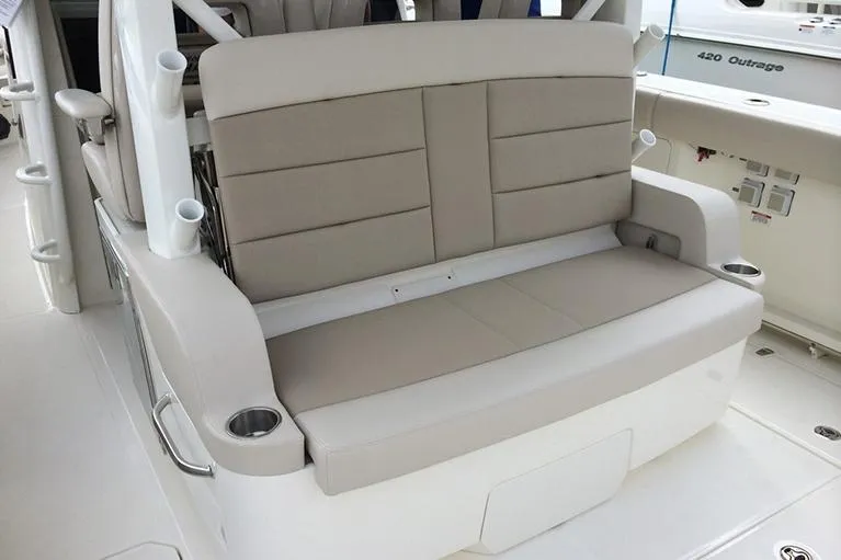 Slide: The Image of Manufacturer Provided Image: 2025 Boston Whaler 380 Outrage boat seating area with beige cushions and cup holders. - 13