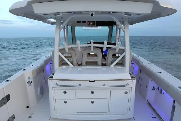 Slide: The Image of Manufacturer Provided Image: 2025 Boston Whaler 380 Outrage boat interior with ocean view, featuring modern seating and storage. - 9