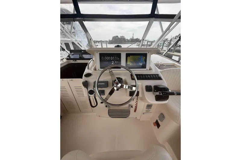 Slide: The Image of Helm of 2013 Grady-White Express 330 boat with navigation screens and steering wheel. - 15