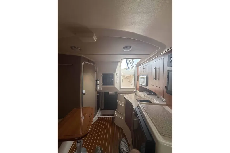 Slide: The Image of Interior of 2013 Grady-White Express 330 boat, featuring kitchen and seating area. - 18