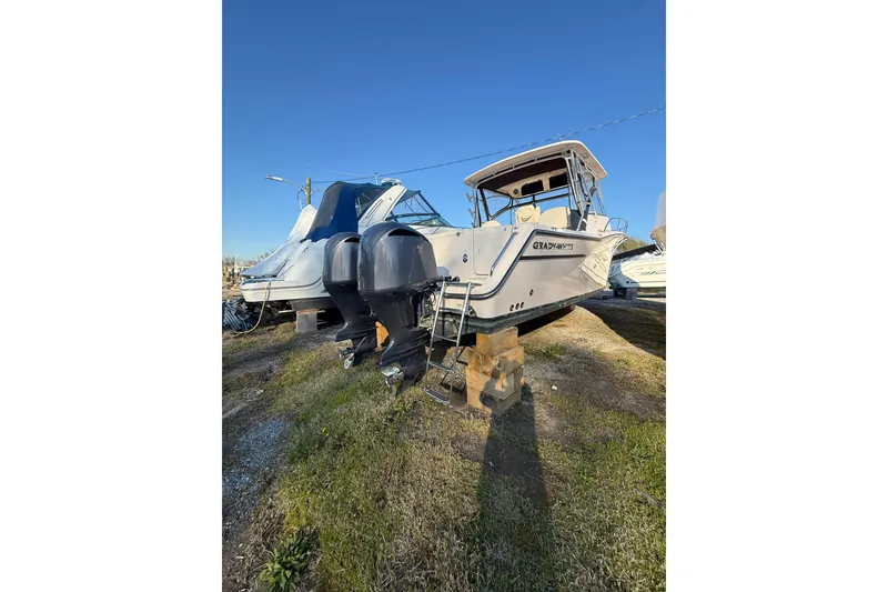 Slide: The Image of 2013 Grady-White Express 330 boat on land, dual engines, clear sky background. - 4