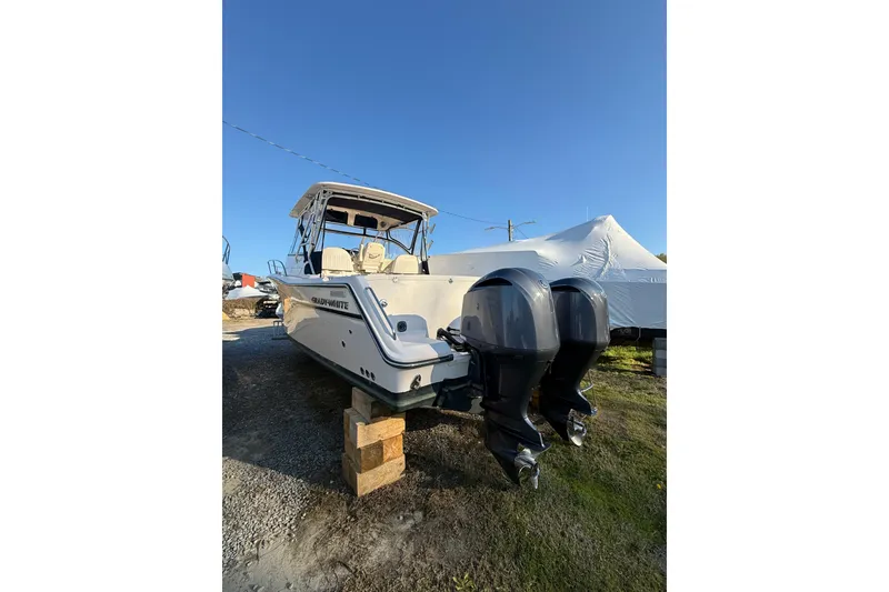 Slide: The Image of 2013 Grady-White Express 330 boat with dual outboard motors on land. - 5