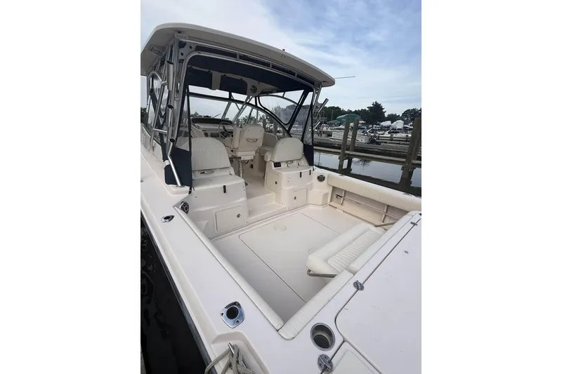 Slide: The Image of 2013 Grady-White Express 330 boat interior with seating and helm, docked at marina. - 9