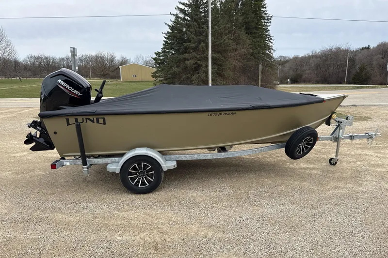 Slide: The Image of 2026 Lund 1675 Alaskan Tiller boat on trailer, covered, with Mercury outboard motor. - 9