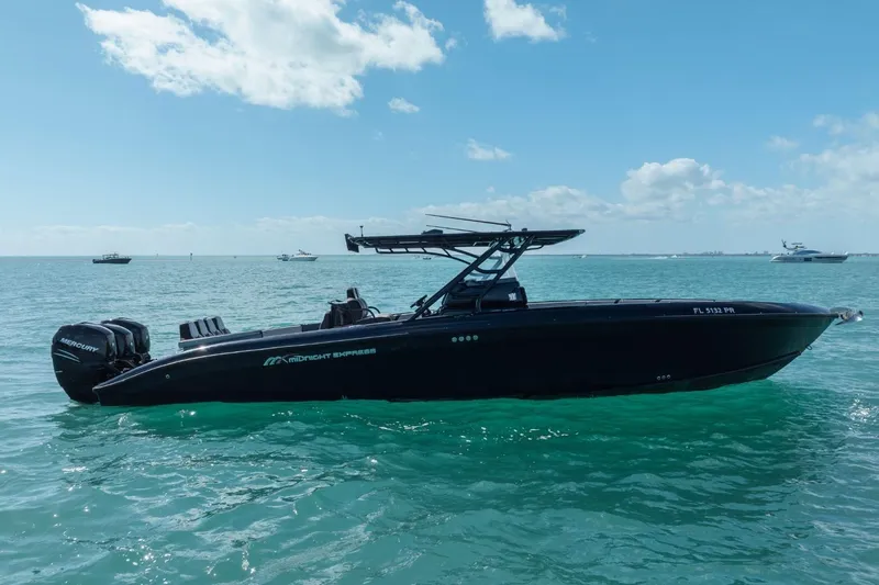 The Image of 2014 Midnight Express 37 Open boat on clear blue water under a sunny sky. - 1