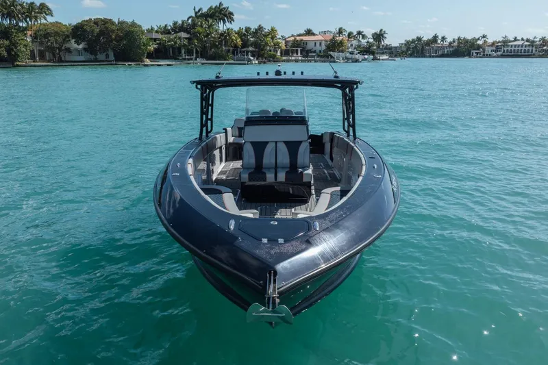 Slide: The Image of 2014 Midnight Express 37 Open boat on turquoise water, with coastal homes in the background. - 10