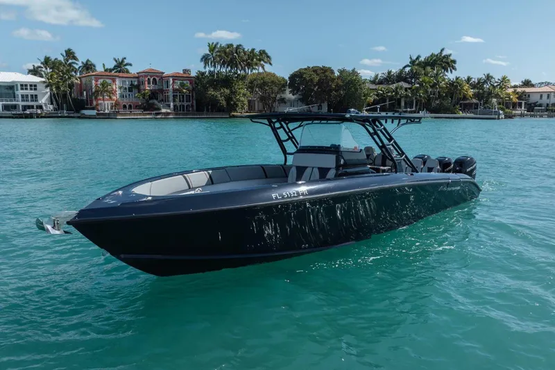 Slide: The Image of 2014 Midnight Express 37 Open boat on turquoise water near luxury waterfront homes. - 4