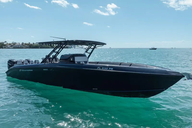Slide: The Image of 2014 Midnight Express 37 Open boat on turquoise water under clear sky. - 7