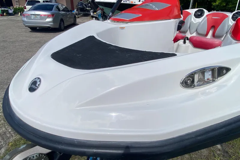 Slide: The Image of 2007 Seadoo 150 Speedster boat with red and white seating, parked outdoors. - 13