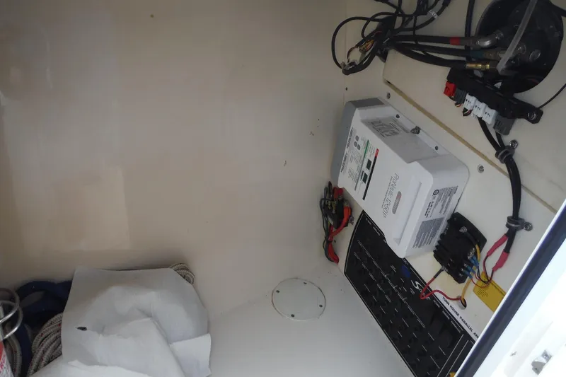 Slide: The Image of Electrical compartment of a 2017 Scout 255 Dorado boat, featuring wiring and control panels. - 16