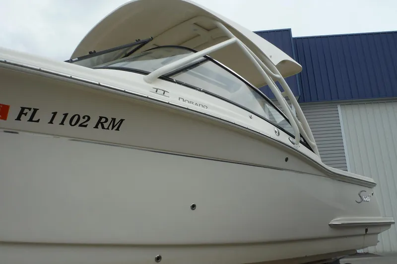 Slide: The Image of 2017 Scout 255 Dorado boat with registration FL 1102 RM, docked near a building. - 3