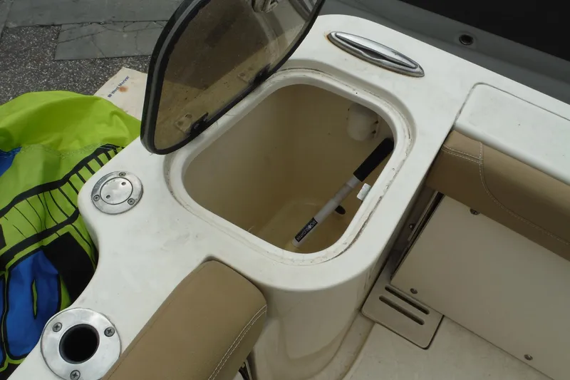 Slide: The Image of Open storage compartment on 2017 Scout 255 Dorado boat with green and black item nearby. - 31
