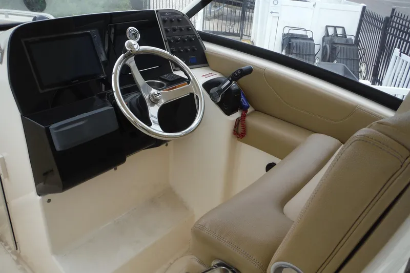 Slide: The Image of 2017 Scout 255 Dorado boat helm with steering wheel and control panel. - 7