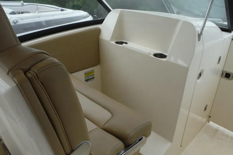Slide: The Image of 2017 Scout 255 Dorado boat interior with beige seating and cup holders. - 8
