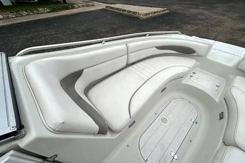 Slide: The Image of 2001 Crownline 239 DB boat interior with white cushioned seating and storage compartments. - 13