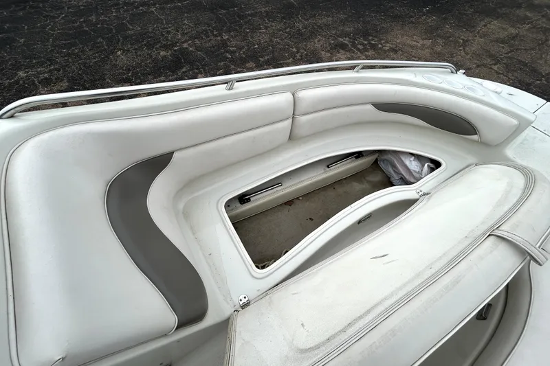 Slide: The Image of 2001 Crownline 239 DB boat interior with white and gray seating and storage compartment. - 14