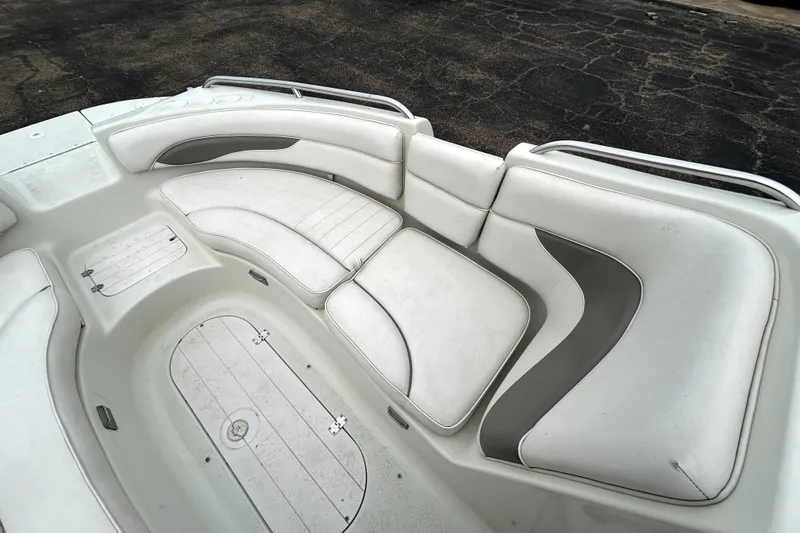 Slide: The Image of 2001 Crownline 239 DB boat interior with white cushioned seating and storage compartments. - 15