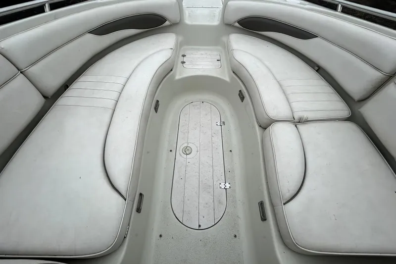 Slide: The Image of Interior seating of a 2001 Crownline 239 DB boat, featuring white cushioned benches. - 19