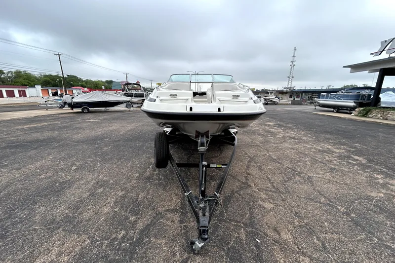 Slide: The Image of 2001 Crownline 239 DB boat on trailer in parking lot, overcast sky. - 2