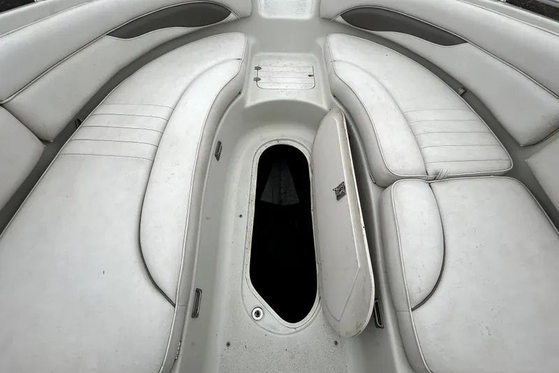 Slide: The Image of 2001 Crownline 239 DB boat interior with white seating and open storage compartment. - 20