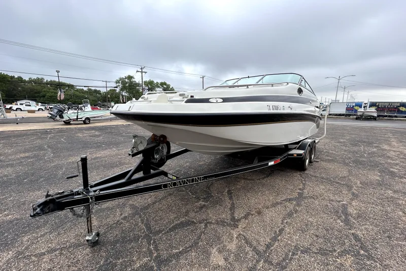 Slide: The Image of 2001 Crownline 239 DB boat on trailer in parking lot, overcast sky. - 3
