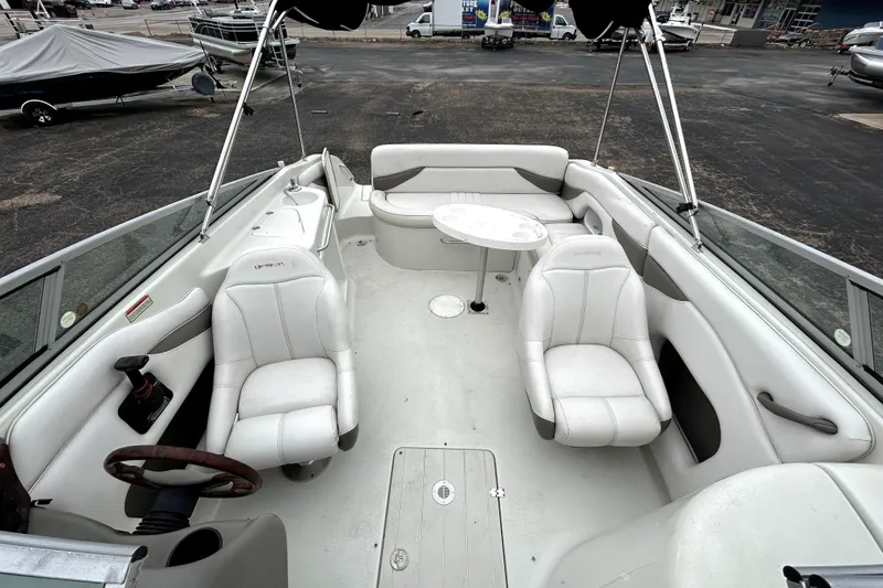 Slide: The Image of 2001 Crownline 239 DB boat interior with white seating and steering wheel. - 32
