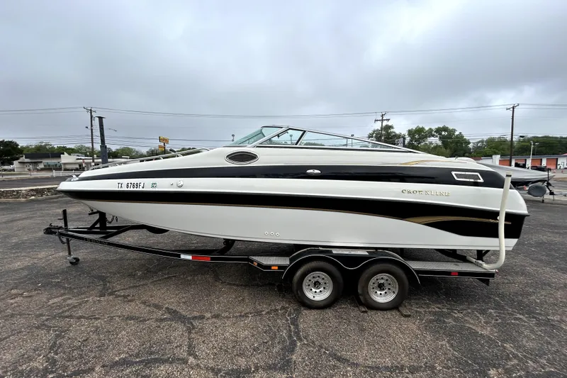 Slide: The Image of 2001 Crownline 239 DB boat on trailer, parked outdoors under cloudy sky. - 4